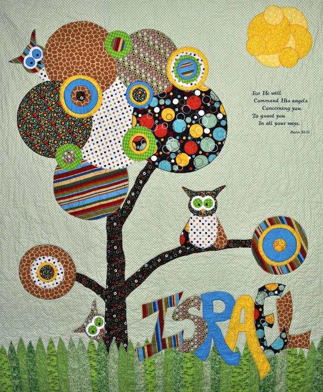 Whimsical applique quilt featuring an owl, tree of circles and the name Israel